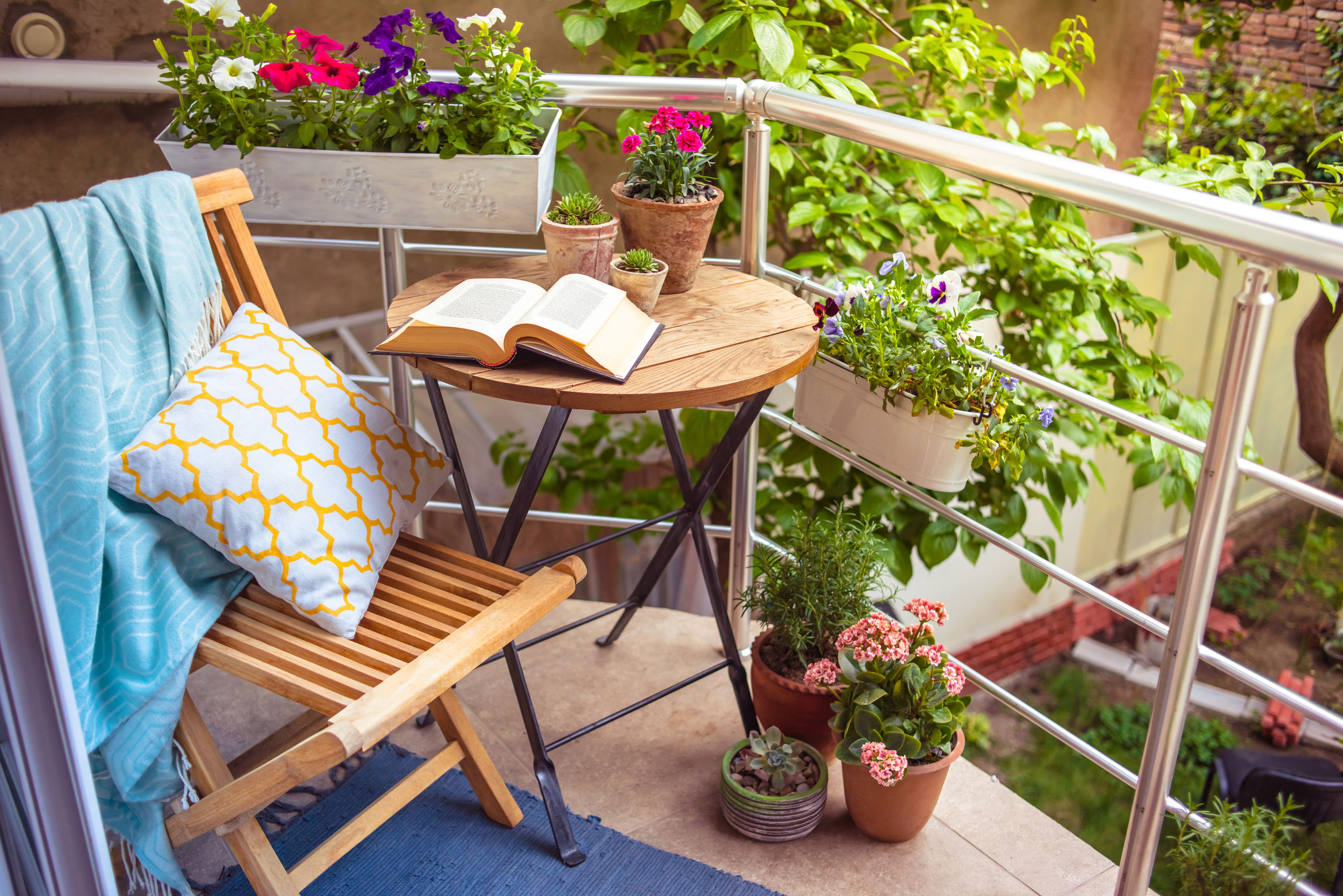 Table ronde en bois avec chaise pliante sur petit balcon